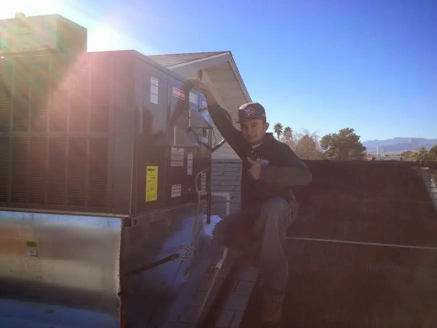 HVAC technician performing Heat Pump Repair on a rooftop unit in Pratt